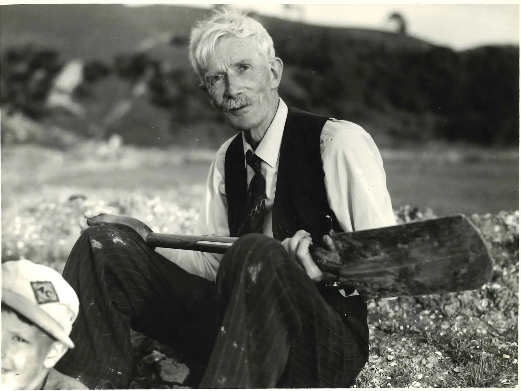 Photograph of A.H. Reed with a spade at kauri park, 1960s. Photograph by Tudor Collins.